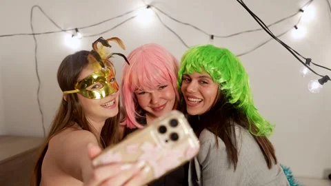 Three cheerful women taking a selfie at a costume party Stock Footage 324465623