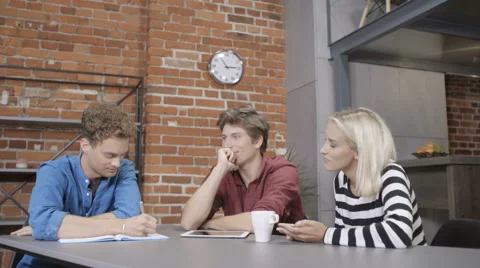 Three cheerful young people discussing project. Stock Footage