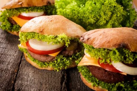 Three cheeseburgers on the table Stock Photos