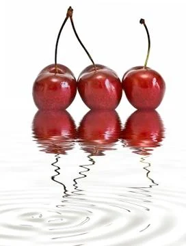 Three cherries reflected on water. Stock Photos