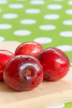 Three cherries on the table cloth with blurred background Foto stock