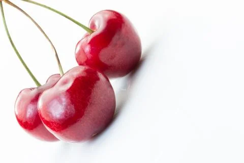 Three cherries tilted on a white background. Stock Photos