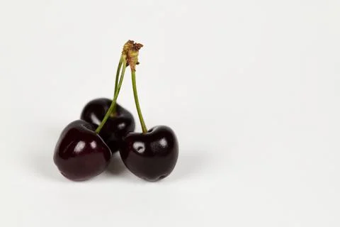 Three cherries on white Stock Photos