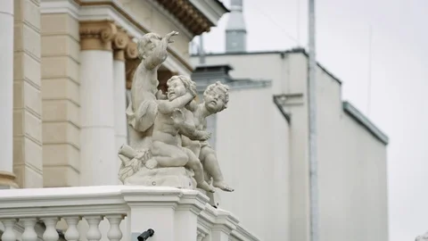 Three cherub little boy statues mounted to hand rail on ornate building Stock Footage 122540823