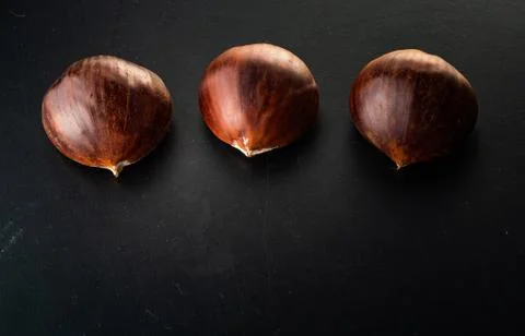 Three chestnuts isolated on black background Stock Photos