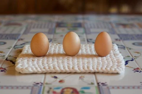 Three chichen eggs on a decorated ceramic table Stock Photos