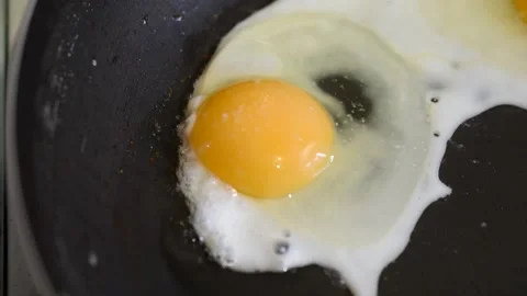 Three chicken eggs in a frying pan for frying food Stock Footage 151787276
