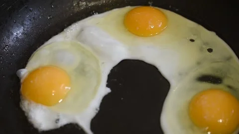 Three chicken eggs in a frying pan for frying food Stock Footage 151787279