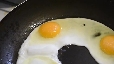Three chicken eggs in a frying pan for frying food Stock Footage 151787281