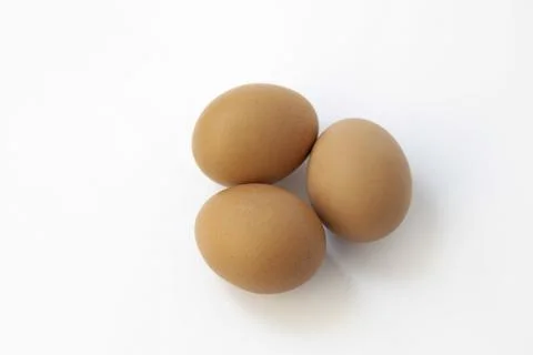 Three chicken eggs isolate on white background. Top view. 库存照片