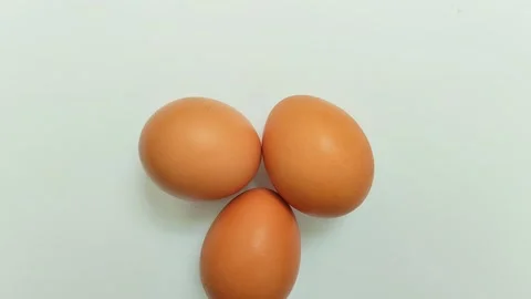 Three chicken eggs on a white background. 스톡 동영상 310291108