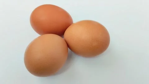 Three chicken eggs on a white background. Stockbeeldmateriaal 310291241