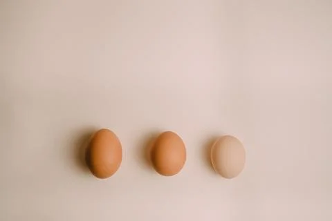 Three chicken eggs on a white background Stock Photos