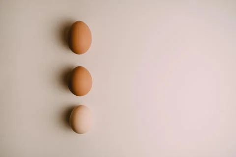 Three chicken eggs on a white background Stock Photos