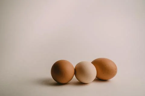 Three chicken eggs on a white background Stock Photos