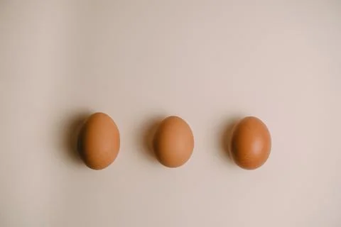 Three chicken eggs on a white background Stock Photos