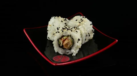 Three chicken sushi roll on black plate rotating Stock Footage 55639463