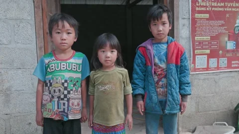 Three children in front of a house in  Yen Minh, Ha Giang, Vietnam Stock Footage 329073386