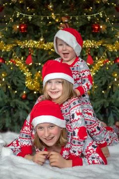 Three children have fun on the background of the Christmas tree. children are Stock Photos