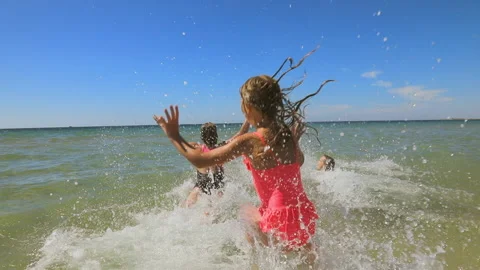 Three children having fun on a beach running to the sea slow motion 스톡 동영상 154503671