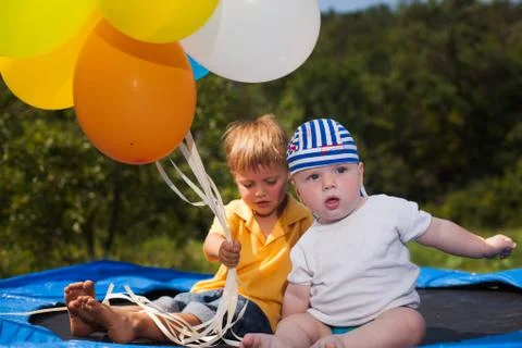 Three children jumping on a trampoline in front of their home Stock-Fotos
