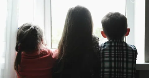 Three children look out the window during Covid-19. Stock Footage 134553621