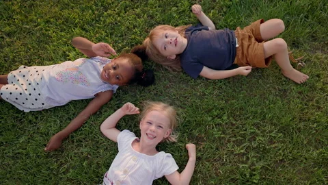 Three Children Lying On Grass. Looks Like Beautiful Summer Sunny Day. Stock-Footage 162630278