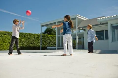 Three children playing with a ball Stock Photos