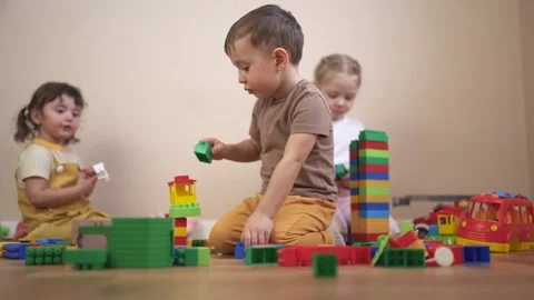 Three children playing with blocks. Children play together in a group. Build a Video stock 316604037
