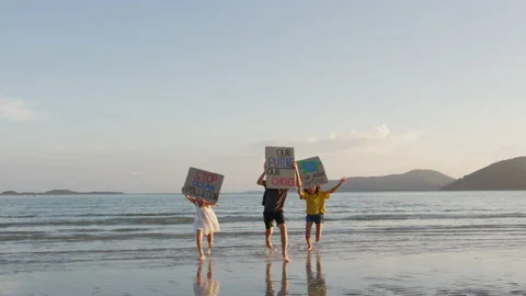 Three children running to the camera, on the seaside, at sunset light. They are Stock Footage 191444782