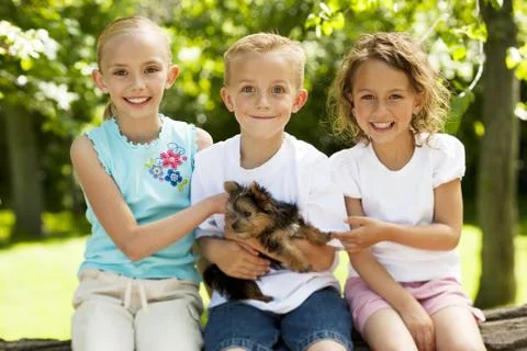 Three children with small dog Stock Photos