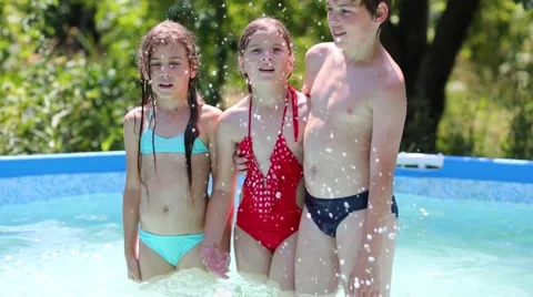 Three children splash and fall in swimming pool in summer garden Stock-Footage 46470940