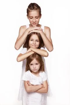 Three children in the studio on a white background, a brother and two sisters Stock Photos