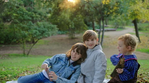Three Children Taking Selfie Together in Autumn Park During Golden Hour Sunset. Vídeo Stock 338139638