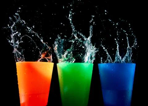 Three children's multicolored plastic cups with splashes Foto stock
