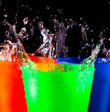 Three children's multicolored plastic cups with splashes Foto stock