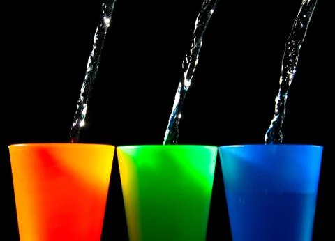 Three children's multicolored plastic cups with splashes Stock Photos