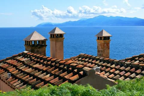 Three chimneys on red tiled rooftops Stock Photos