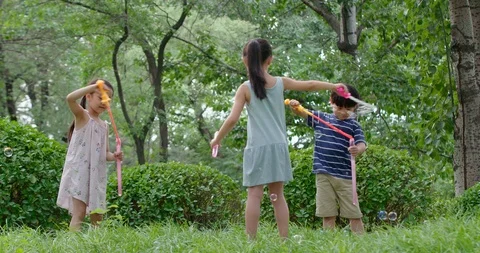 Three Chinese children blowing bubbles on grass,4K Stock Footage 119087819
