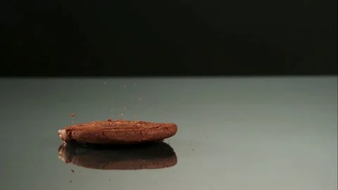 Three chocolate chip cookies drop and bounce on a shiny mirror surface Stock Footage 326627075