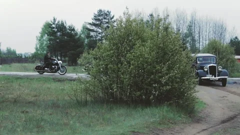 Three choppers pass a retro car in the countryside Stock Footage 247901037