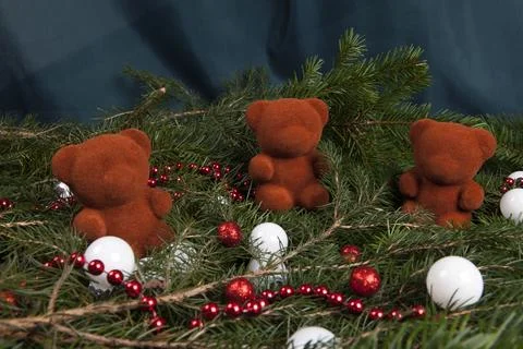 Three christmas bauble teddy bear placed on a pile of fir branches Stock Photos