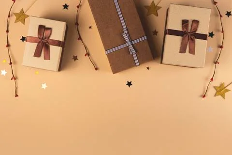 Three Christmas gift boxes on a neutral background among decorations Stock Photos