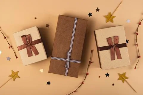 Three Christmas gift boxes on a neutral background among decorations Stock Photos