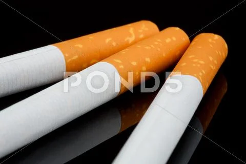 Three Cigarettes On Black Reflective Background Studio Close Up Shot Stock Photos