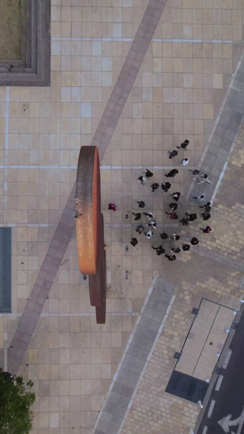 Three-circle sculpture creates abstract patterns as people walk beneath in Vídeos de archivo 310602401