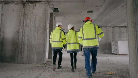 Three civil engineers are walking in under-construction building, real estate Stock Footage 201943764