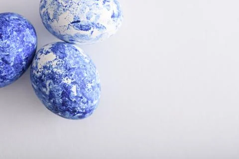 Three classic blue Easter eggs with gradient effect in corner on white backgr Stock Photos