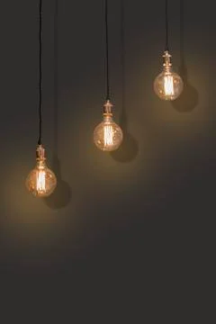 Three classic Edison lights bulb isolated on black background with space. Stock Photos