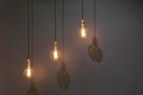 Three classic Edison lights bulb isolated on black background with space. Stock Photos